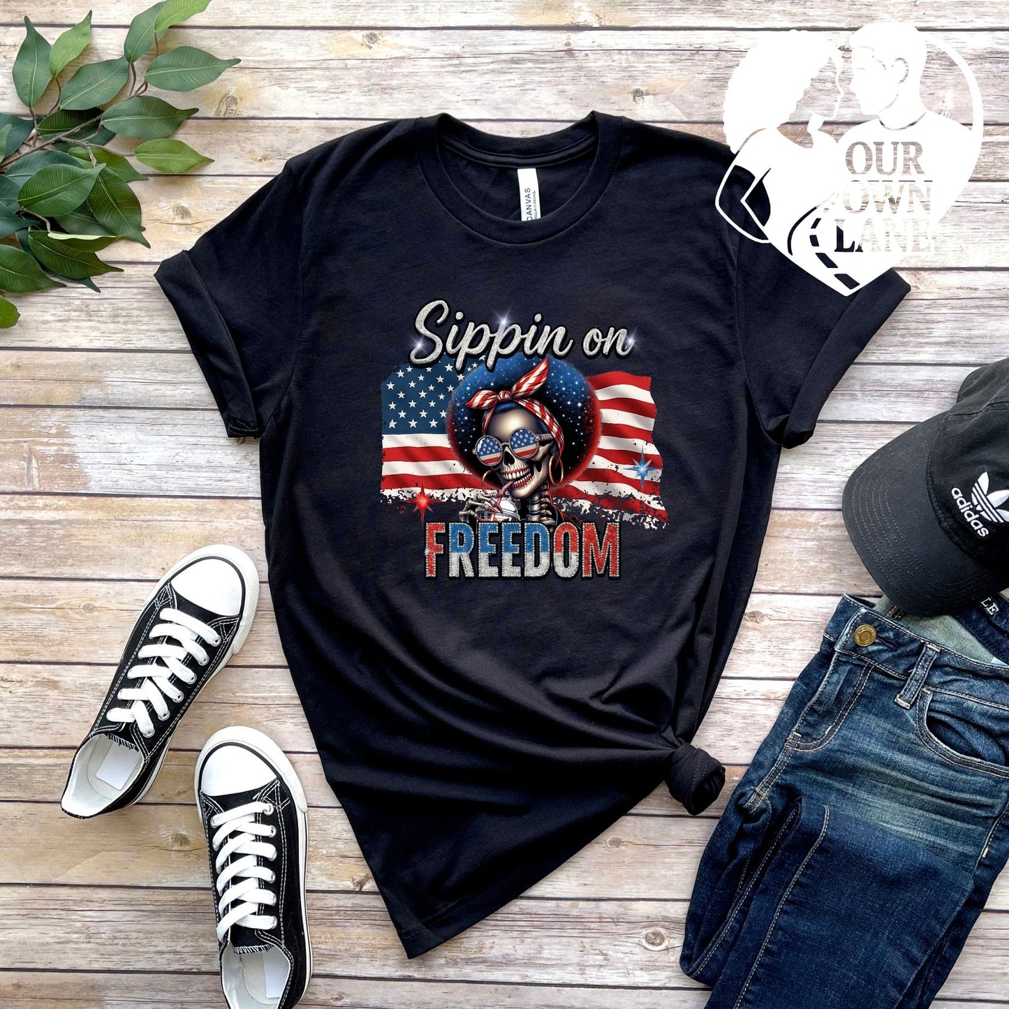 Black unisex t-shirt featuring Sippin on Freedom patriotic skeleton graphic by Our Own Lane