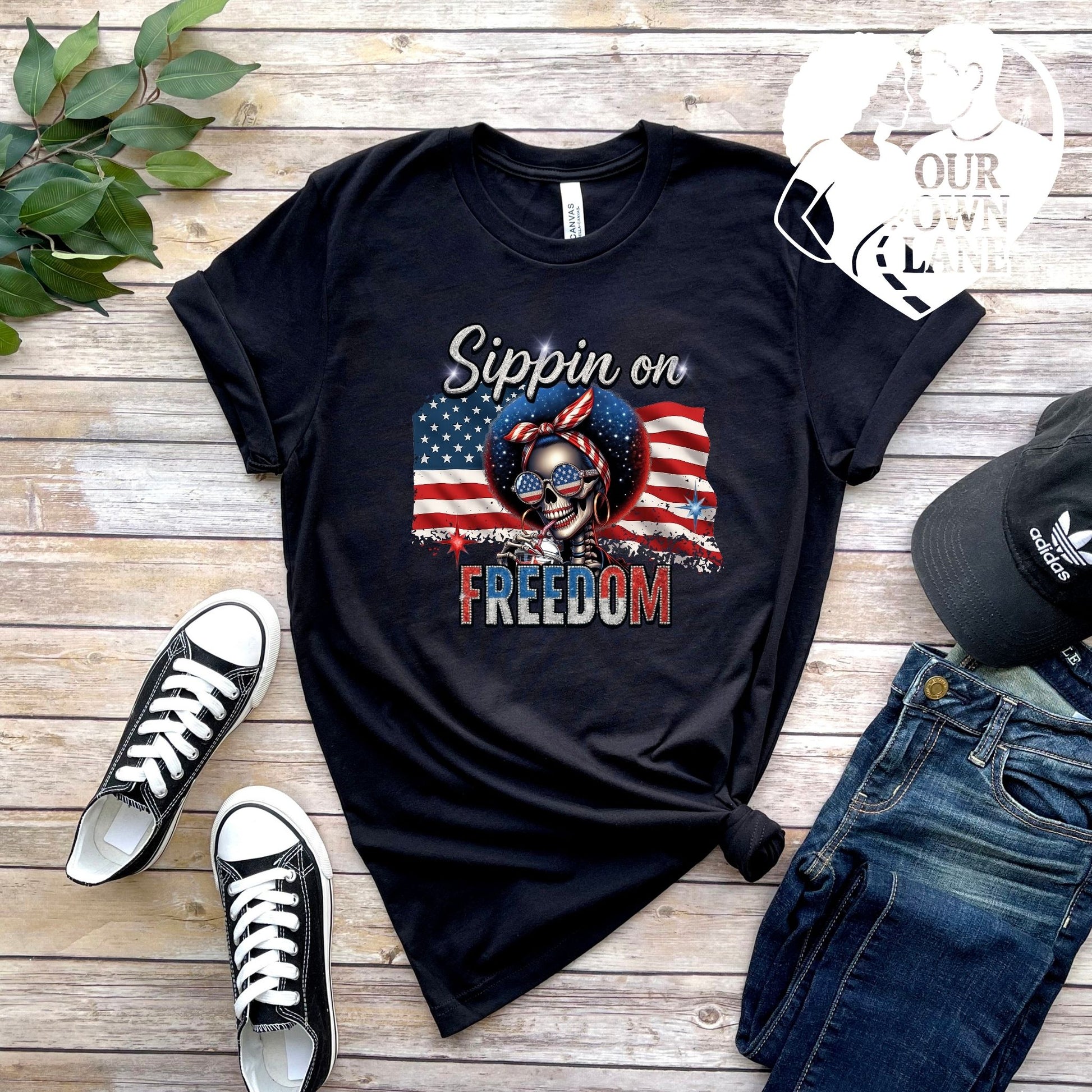 Black unisex t-shirt featuring Sippin on Freedom patriotic skeleton graphic by Our Own Lane