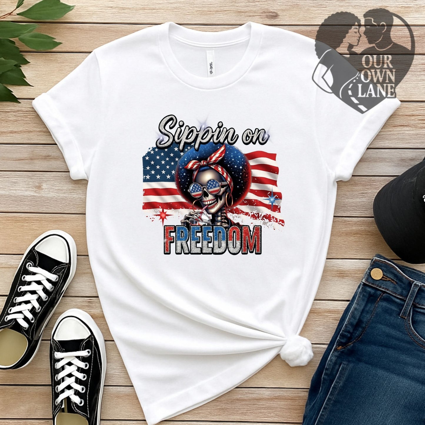 White unisex t-shirt featuring Sippin on Freedom patriotic skeleton graphic by Our Own Lane